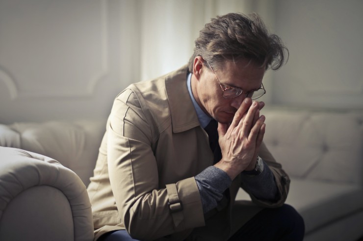 uomo triste con mani sul viso
