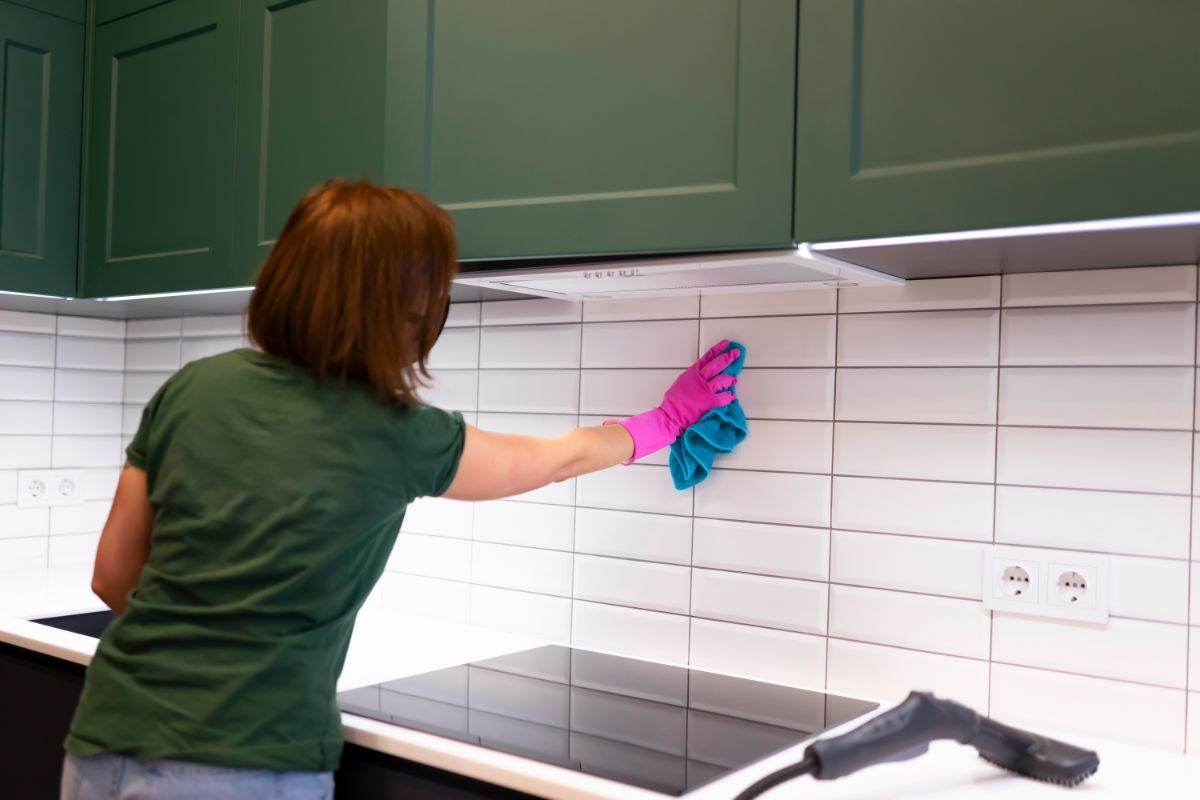 donna che pulisce piastrelle cucina